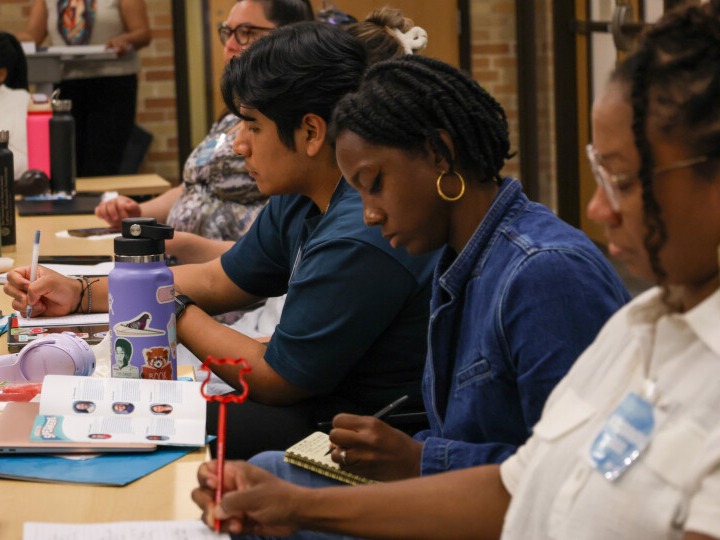 Scholars at the annual Summer Doctoral Institute listen to a lecture while writing notes.