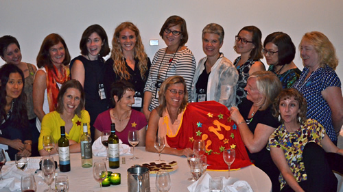 Williams is given the Mentoring Award and a superhero cape at the SWS banquet at ASA, surrounded by students and colleagues.