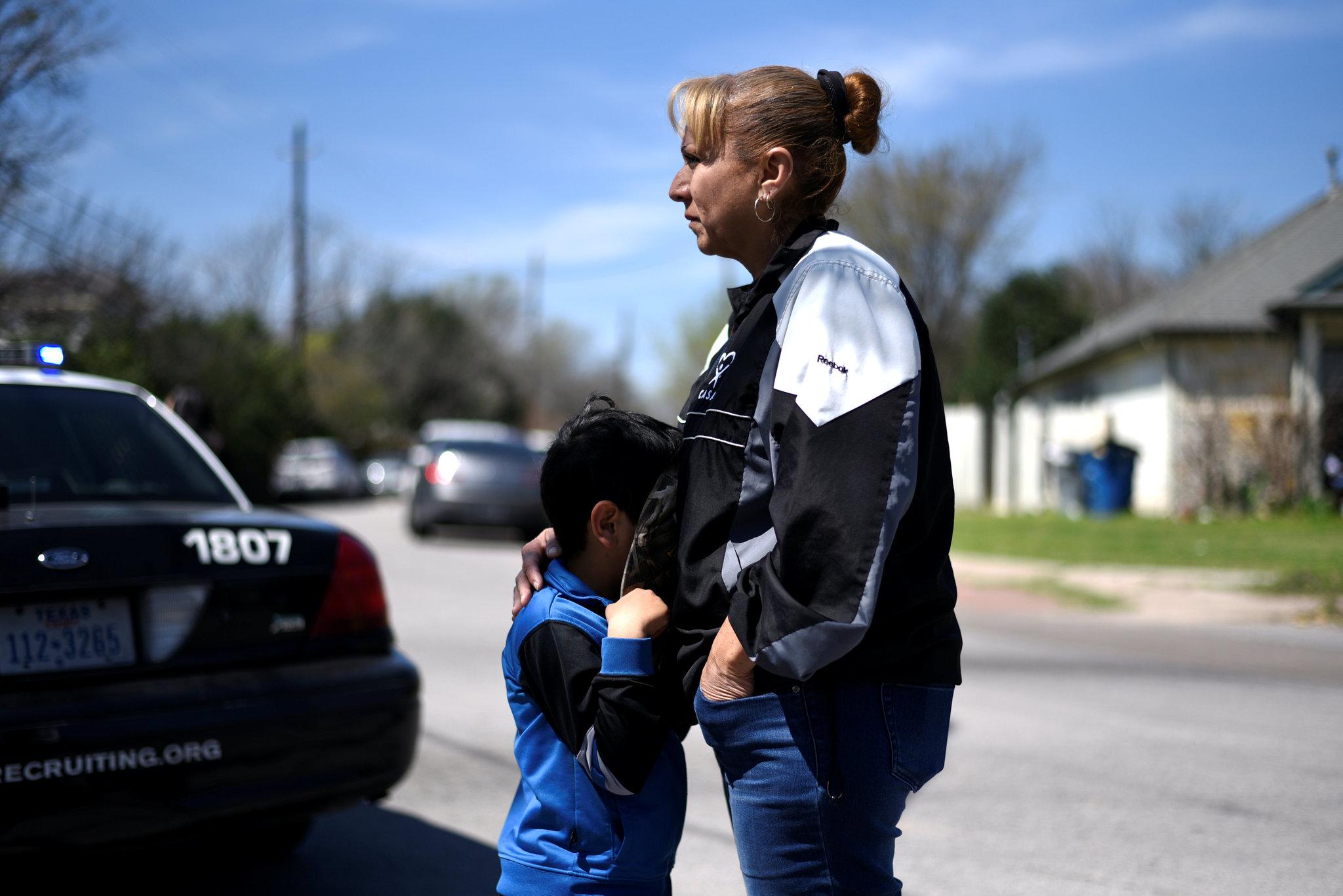 Isaac Machado and his mother, Delores, stand near the scene of a package bomb explosion in Austin, TX, on March 12. Credit: Sergio Flores/Reuters