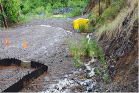 Runoff with stormwater infrastructure and detention pond in the background