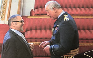 Prof. Emeritus Ian Hancock receiving a medal from Prince Charles