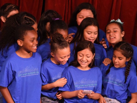 image of schoolchildren in blue shirts crowded together